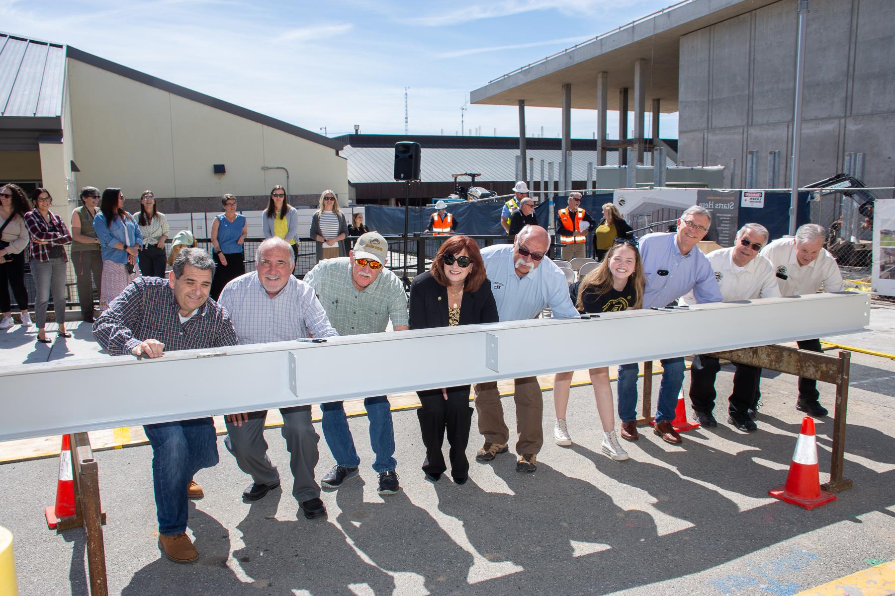 The Butte College Superintendent/President and Board of Trustees are seen signing a steel beam. 